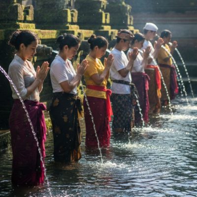 Praktik Seni Meditasi air melukat di pancuran suci Tirta Empul Bali untuk penyembuhan batin.